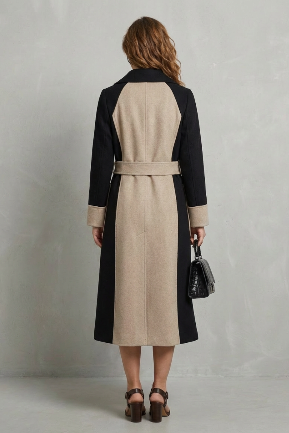Donna indossa un cappotto doppiopetto longilino bicolore con revers e dettagli a contrasto, abbinato a sandali neri._3