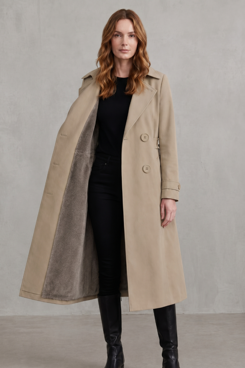 Donna che indossa un cappotto doppiopetto beige aperto per mostrare la fodera interna morbida, abbinato a pantaloni neri e top scuro._9