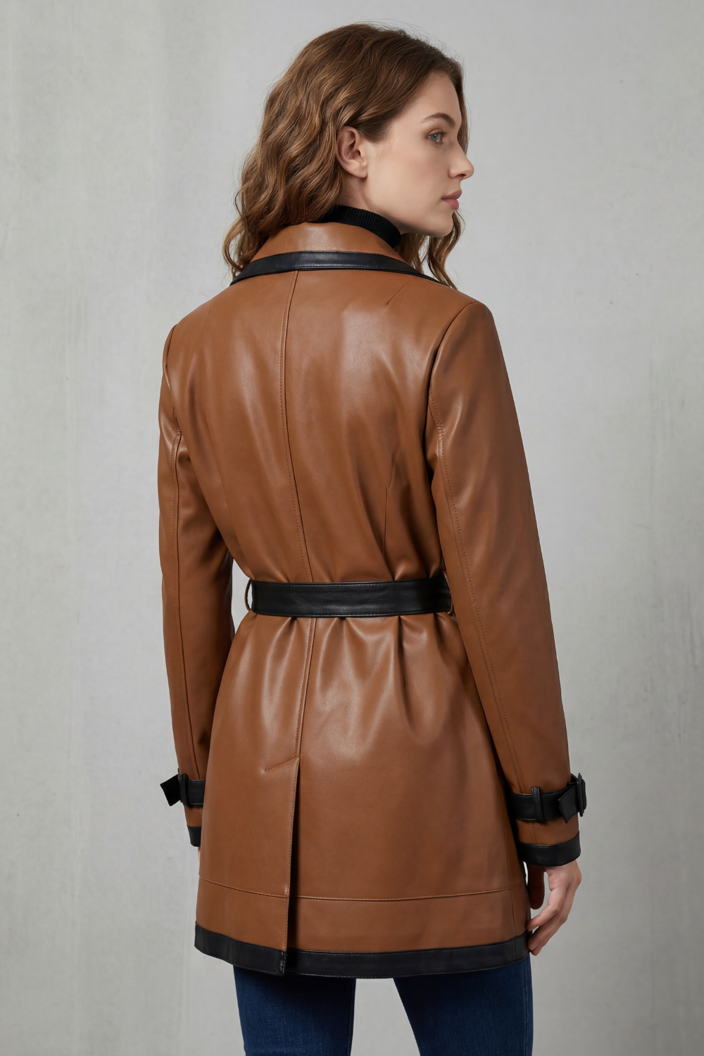 Modella indossa un trench coat marrone con dettagli neri a contrasto e cintura in vita._3
